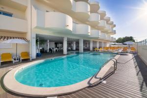 a swimming pool on the roof of a hotel at AlvorMar Apartamentos Turisticos in Alvor