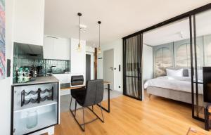a kitchen and a bedroom with a bed and a desk at Central Panorama Apartment Chmielna 35 by BookingHost in Warsaw