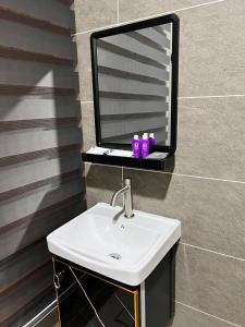 ein Bad mit einem Waschbecken und einem Spiegel in der Unterkunft BEATRIX HOTEL in Brinchang