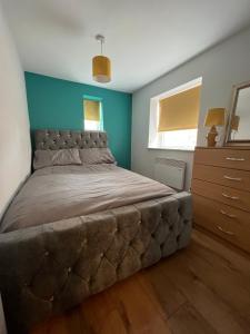 a bedroom with a large bed and a blue wall at Cairo Street in Warrington