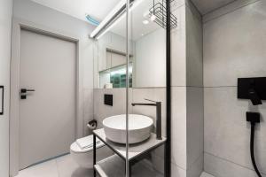 a bathroom with a sink and a toilet at Central Panorama Apartment Chmielna 35 by BookingHost in Warsaw +24 photos