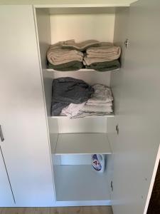 un placard avec des étagères blanches et des serviettes pliantes dans l'établissement Mysig & lugn lägenhet centralt, à Helsingborg
