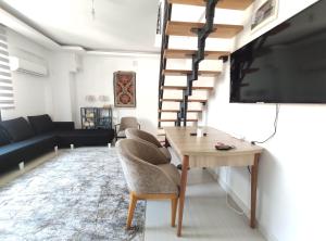 ein Wohnzimmer mit einem Tisch und einem Flachbild-TV in der Unterkunft Denizolgun Homes Tenim Suit Apart 3 in Dalaman