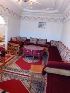 ein Wohnzimmer mit Sofas und einem Tisch in der Unterkunft Bel Appartement à El kelaa Des Srarhna in El Kelaa des Srarhna