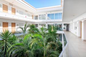 un patio interior con palmeras en un edificio en AlvorMar Apartamentos Turisticos en Alvor