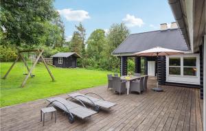 un patio con mesa, sillas y un columpio en Stunning Home In Stege With Wifi, en Pollerup Kullegård