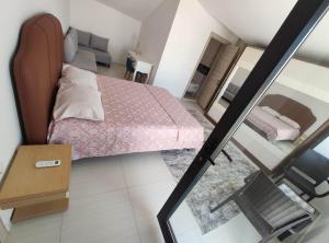 ein kleines Schlafzimmer mit einem Bett und einem Sofa in der Unterkunft Denizolgun Homes Tenim Suit Apart 3 in Dalaman