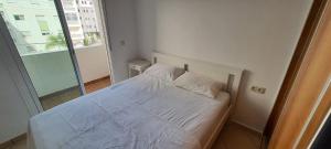 ein weißes Bett in einem Zimmer mit Fenster in der Unterkunft Urban corner in Tétouan