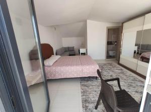 ein kleines Schlafzimmer mit einem Bett und einem Stuhl in der Unterkunft Denizolgun Homes Tenim Suit Apart 3 in Dalaman