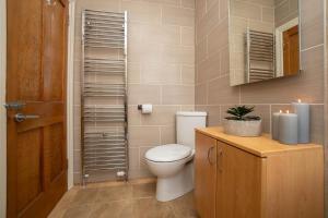 a bathroom with a toilet and a sink and a mirror at Dwellcome Home Ltd 3 Double Bedroom Semi with Garden and Drive in Aberdeen