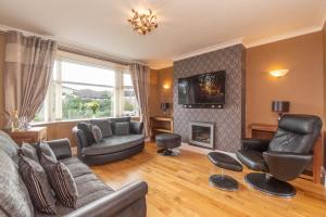 a living room with a couch and chairs and a fireplace at Dwellcome Home Ltd 3 Double Bedroom Semi with Garden and Drive in Aberdeen
