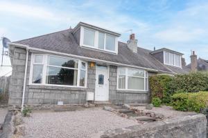 a house with a white door and windows at Driveway Parking for 2 Vehicles, 3 Bedroom House, 2 Kings 1 Double, Garden, Fast WIFI, Ideal for Long Term Contractor, etc Stays, Regular Housekeeping Option - See Our Dwellcome Home Ltd Site for Assurance in Aberdeen