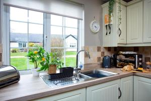 a kitchen with a sink and a window at Puffin Leigh Cottages in Seaton