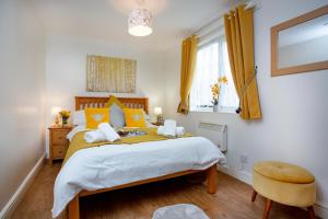 a bedroom with a large bed with orange pillows at Puffin Leigh Cottages in Seaton