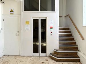 korytarz ze schodami i drzwiami w budynku w obiekcie Modernist Studio in Fitzrovia w Londynie