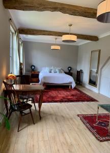 um quarto com uma cama, uma secretária e uma mesa em Château Le Repos em Rouffignac-de-Sigoulès