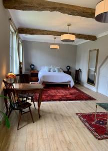 a bedroom with a bed and a desk and a table at Château Le Repos in Rouffignac-de-Sigoulès