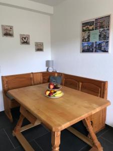 a wooden table with a bowl of fruit on it at Erholung im Westerwald ! in Hachenburg