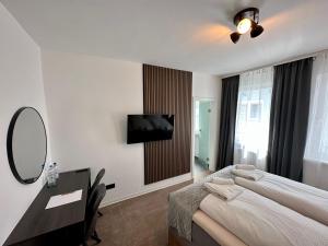 a bedroom with a bed and a desk and a mirror at Hotel Emilia in Würzburg