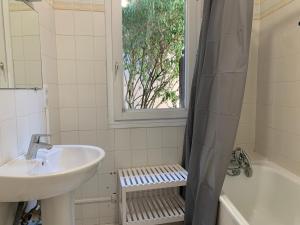 a bathroom with a sink and a tub and a window at Studio Brides-les-Bains, 1 pièce, 2 personnes - FR-1-512-126 in Brides-les-Bains