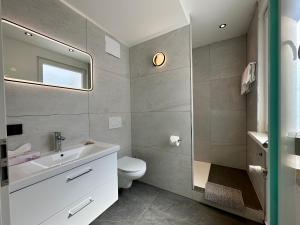 a bathroom with a sink and a toilet and a mirror at Hotel Emilia in Würzburg