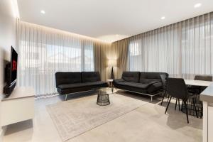 a living room with two black couches and a table at THE SHORE COOGEE BEACH (3) in Sydney