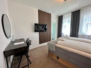 a bedroom with a bed and a desk and a mirror at Hotel Emilia in Würzburg