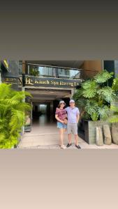 a man and a woman standing in front of a building at HƯƠNG LAN HOTEL in Ho Chi Minh City