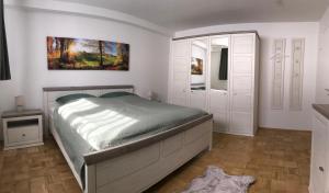 哈亨堡的住宿－Erholung im Westerwald !，卧室配有一张床,墙上挂有绘画作品
