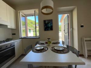 a kitchen with a table with chairs and two windows at Il Fiume by Holiday World in Castagnelo