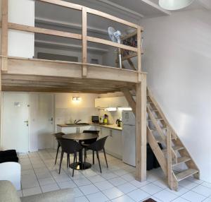 un lit en mezzanine avec une table et des chaises dans une cuisine dans l'établissement Lotentik residence, à La Rochelle