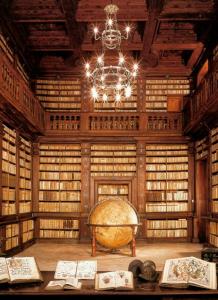 une grande bibliothèque avec un grand globe et un lustre dans l'établissement Casa vacanze nel centro storico di Fermo Happy Song, à Fermo
