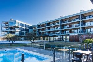an apartment complex with a swimming pool and a building at Depto - Lago los Molinos in Potrero de Garay