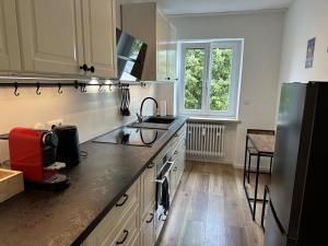 a kitchen with a sink and a refrigerator at MM Lodge - Apartments in Innenstadtlage mit Parkplatz in Augsburg