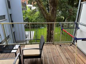 una terraza con una silla, un columpio y un árbol en MM Lodge - Apartments in Innenstadtlage mit Parkplatz en Augsburg