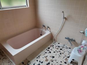 a bathroom with a bath tub and a toilet at 福寿苑　Fukujuen in Oshino