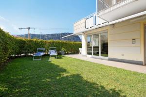 two chairs sitting on a lawn next to a building at Appartamento Sole Torbole in Nago-Torbole