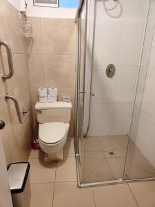 a bathroom with a toilet and a glass shower at Apartamento Florentino 101 in Lima