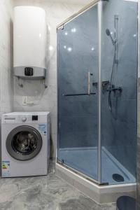 a shower in a bathroom with a washing machine at barasport city apartments in Kyiv