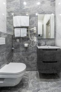 a bathroom with a toilet and a sink and a mirror at barasport city apartments in Kyiv