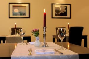 Una mesa con una vela y dos vasos. en Haus Geistmeier en Lippstadt
