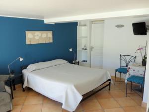 a bedroom with a bed and a blue wall at Le Mas des Amandiers in Saint-Paul-de-Vence