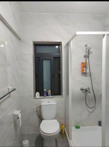 a white bathroom with a toilet and a shower at CASA GRIMA - private double room in Birkirkara