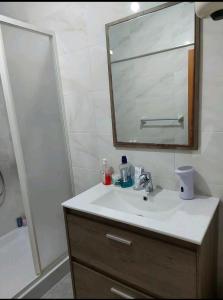a bathroom with a sink and a mirror and a shower at CASA GRIMA - private double room in Birkirkara