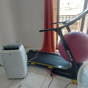 a room with a treadmill and a chair next to a window at CASA GRIMA - private double room in Birkirkara