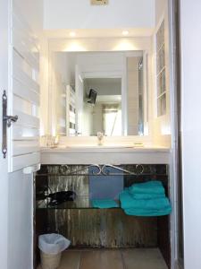 a bathroom with a sink and a mirror at Le Mas des Amandiers in Saint-Paul-de-Vence