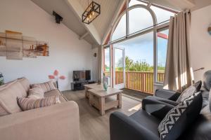 a living room with furniture and a large window at Grimaud 149 - Kustpark Village Scaldia in Hoofdplaat