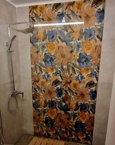 een douchecabine met bloemenbehang in een badkamer bij La Piccola Oasi con parcheggio in Florence