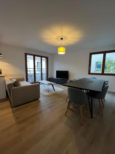 a living room with a couch and a table at Appartement Porte de Paris / Stade de France in Saint-Denis