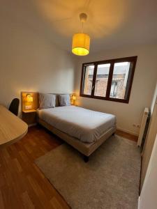a bedroom with a bed and a window at Appartement Porte de Paris / Stade de France in Saint-Denis